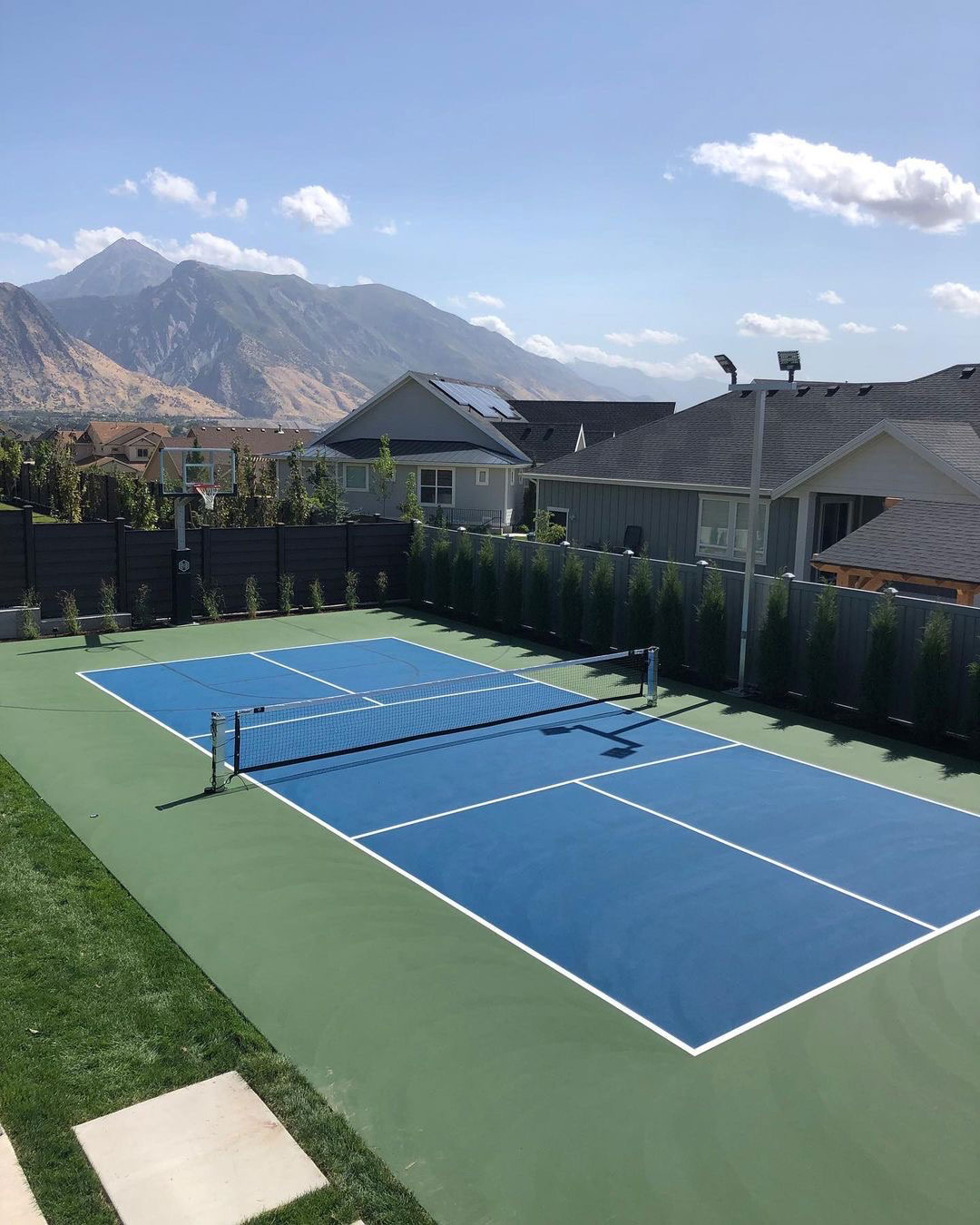 Backyard pickleball and basketball court with mountain views