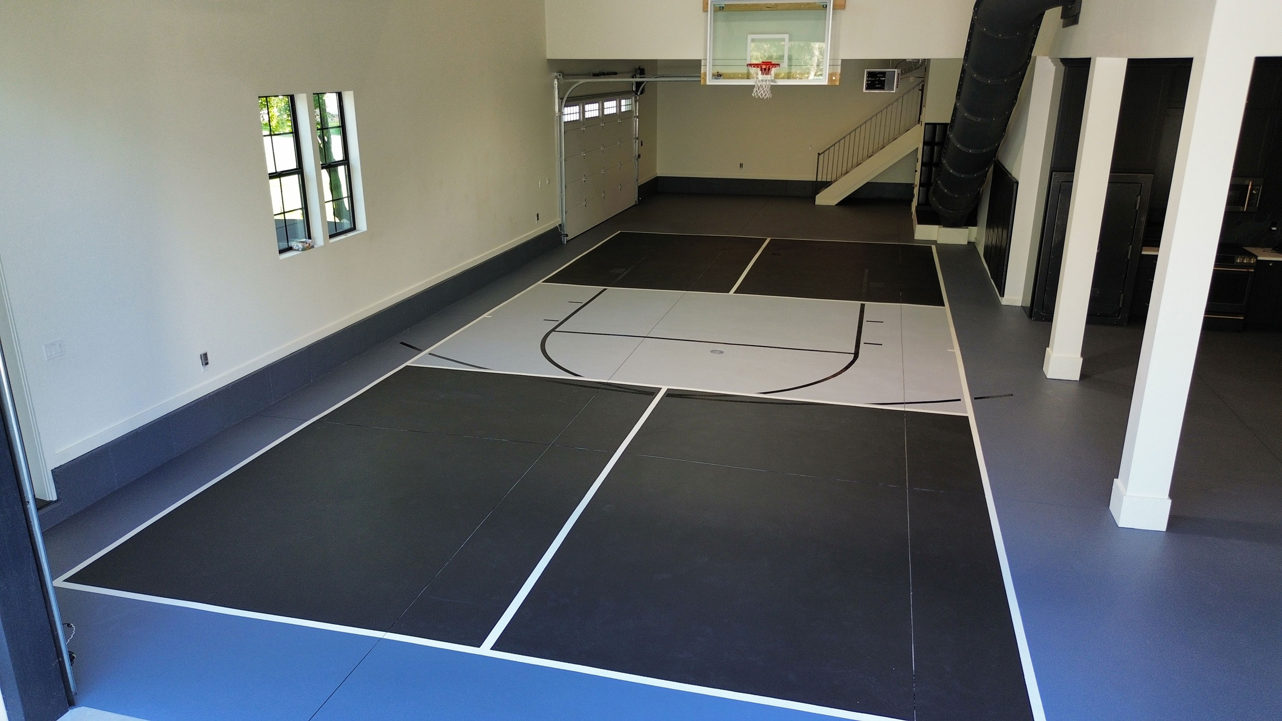 Garage-side pickleball and basketball court in residential setting